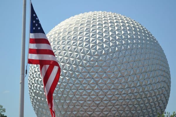 american flag in front of spaceship earth