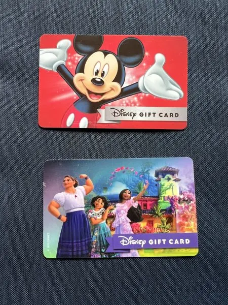 Two Disney gift cards. Top one is standard, bottom one is Encanto themed.