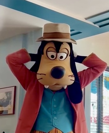 goofy signing an autograph book behind his head