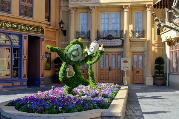 cogsworth and lumiere topiaries in front of impressions de france