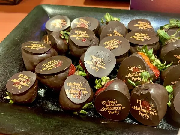 chocolate covered strawberries with mickey's not so scary halloween party printed on them